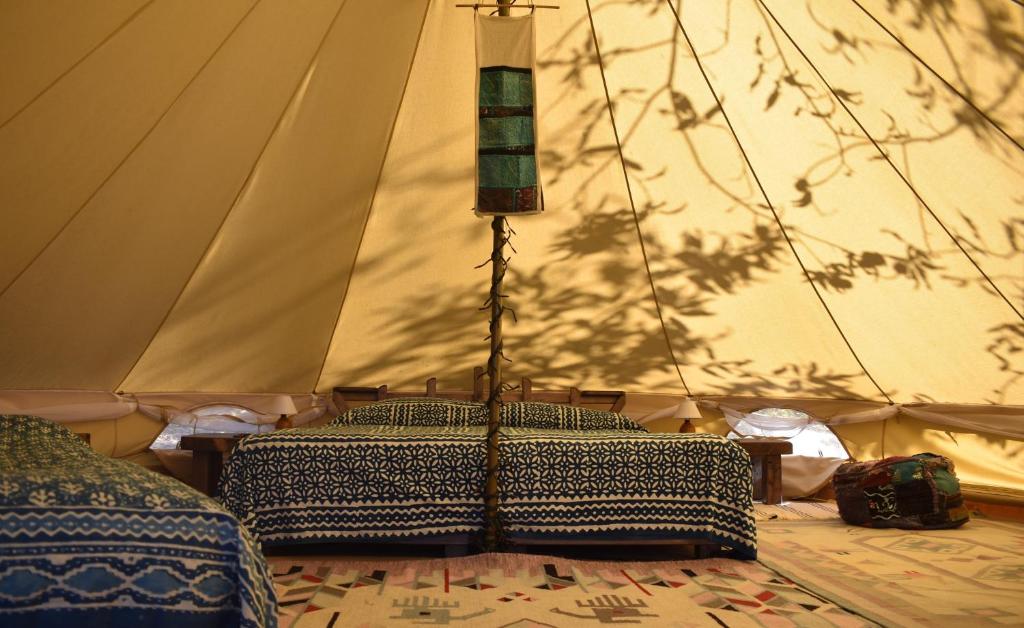 サンタ・フィオーラにあるPodere di Maggio - Glamping tent 2のテント(ベッド1台、ランプ付)が備わる客室です。