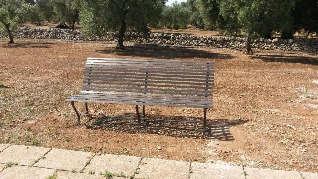 a park bench sitting in the middle of a field at Case d'Artista in Savelletri di Fasano