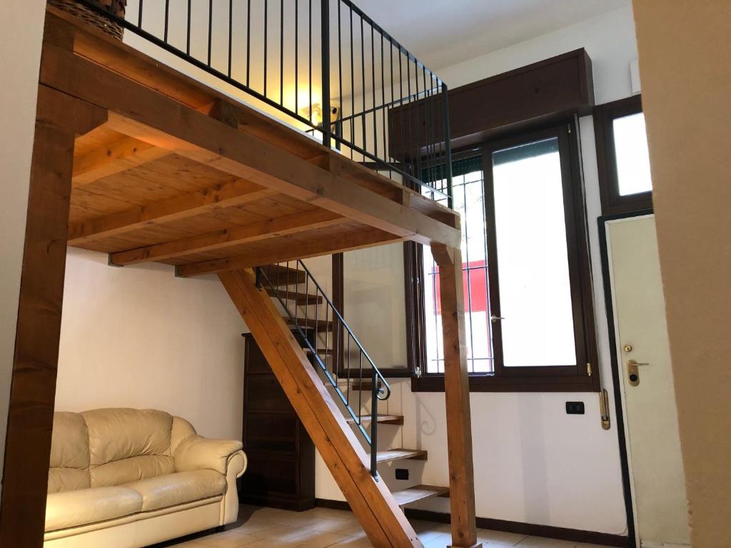 escalera de caracol en una sala de estar con sofá en Pizzardi39 - The Place Apartments en Bolonia