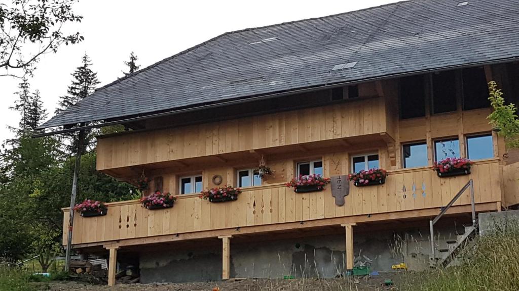 una casa con cajas de flores a un lado. en b&b krättli, en Eggiwil