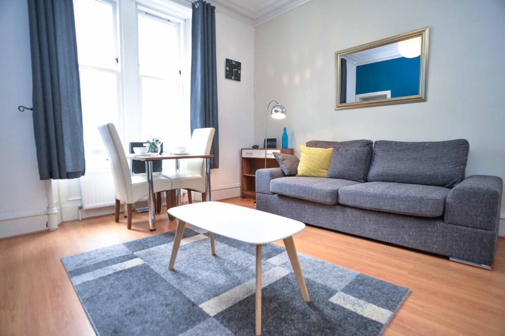uma sala de estar com um sofá e uma mesa em Modern Flat in Rosemount/City Centre em Aberdeen