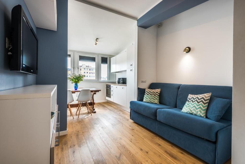 ein Wohnzimmer mit einem blauen Sofa und einem Tisch in der Unterkunft Expeditus VATICAN Luxury Suites SAINT PETER'S VIEW in Rom