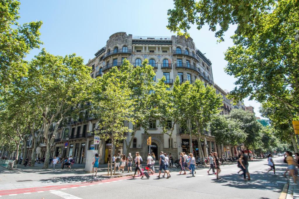 people crossing the street in front of a building at Safestay Barcelona Passeig de Gràcia in Barcelona