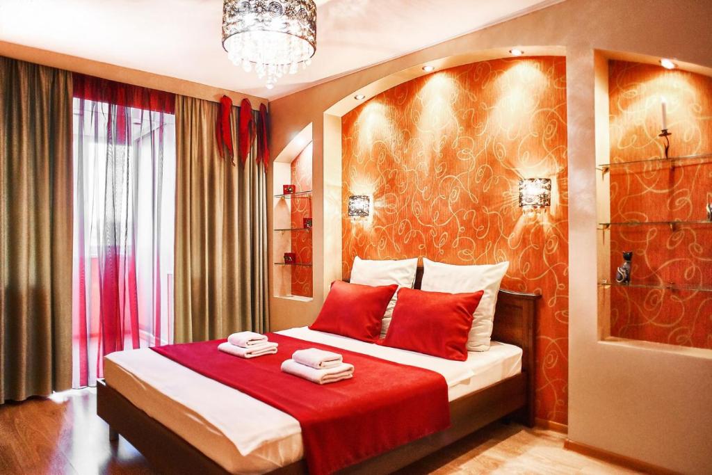 マグニトゴルスクにあるFive Stars Red Diamondの赤いシーツを使用したベッドが備わるホテルルームです。