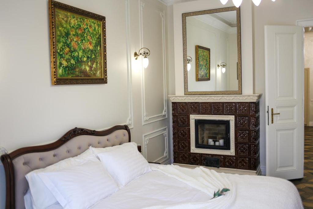 - une chambre avec un lit, une cheminée et un miroir dans l'établissement Del Rey Luxury, à Lviv