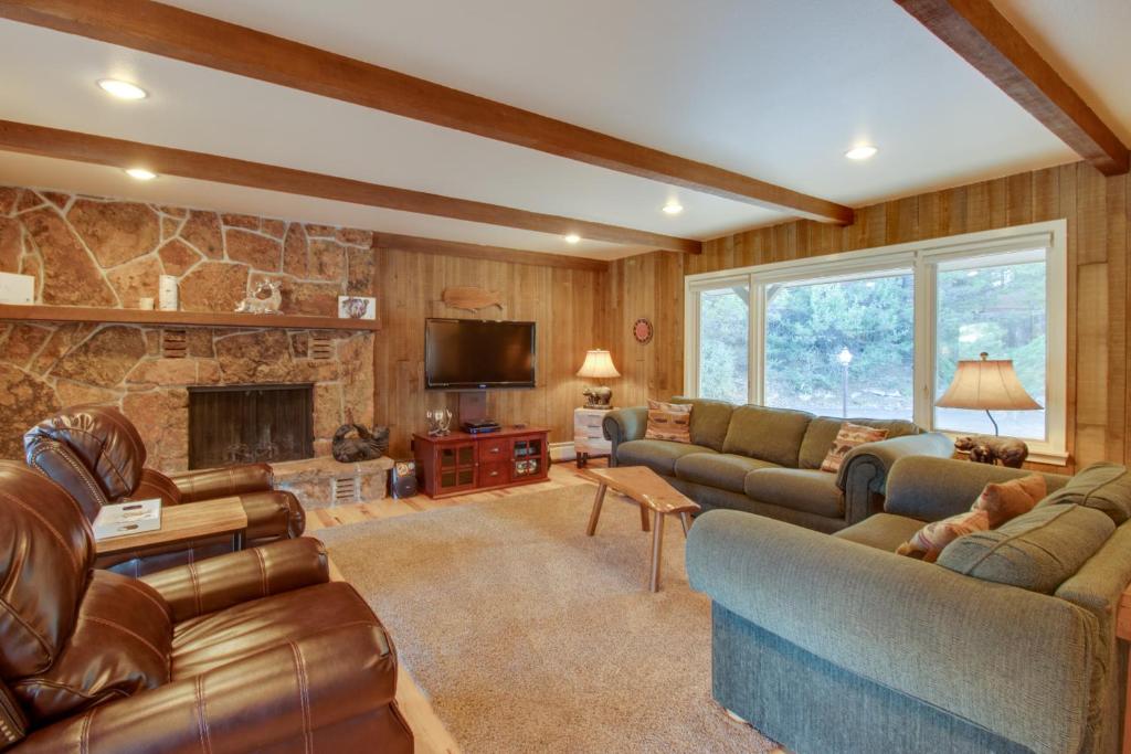 a living room with couches and a stone fireplace at Cottage of Course - Permit #3092 in Estes Park