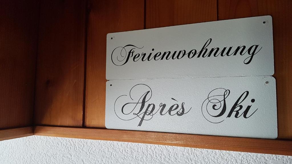 dos letreros en una pared de madera con las palabras fertilizando el fuego en Ferienwohnung Apres Ski en Schruns