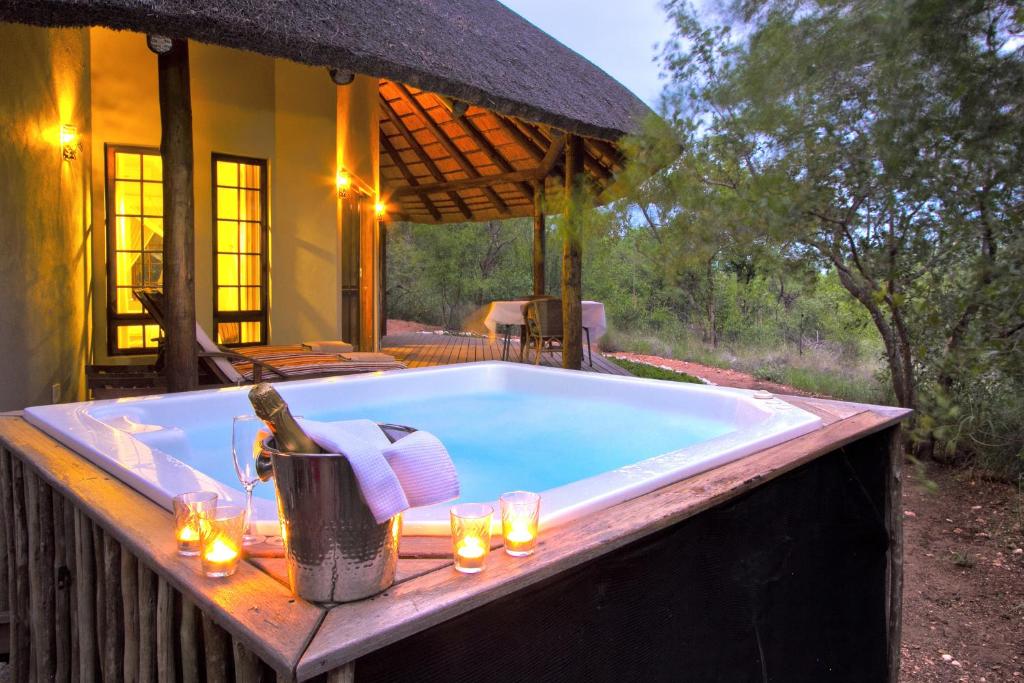 a bath tub with a table and candles in front of a house at Casart Game Lodge in Grietjie Game Reserve