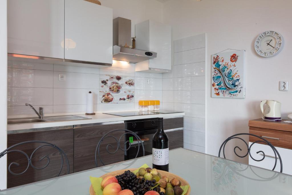 una cocina con un bol de fruta y una botella de vino en Holiday Home Barbara, en Trogir