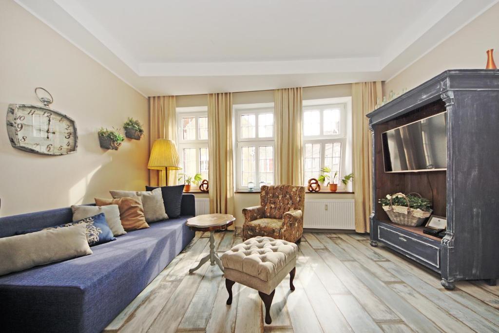 Retro Apartament na Starowce في غدانسك: غرفة معيشة مع أريكة زرقاء وتلفزيون