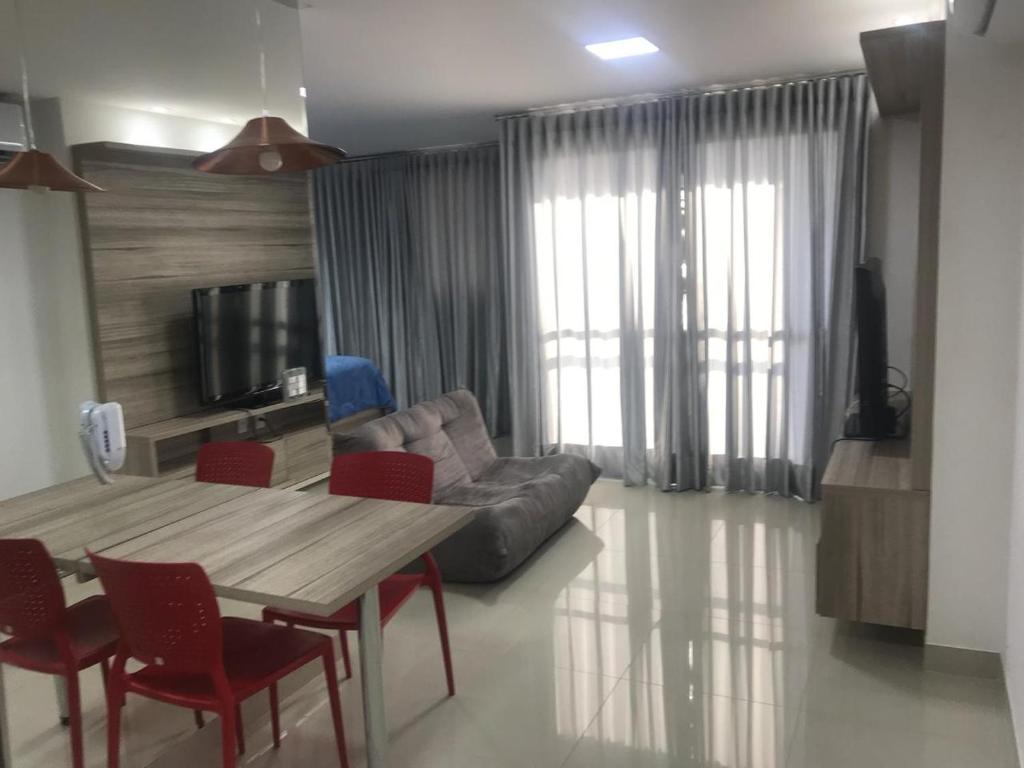 uma sala de estar com uma mesa e um sofá em Lounge 22 Home Design em Goiânia