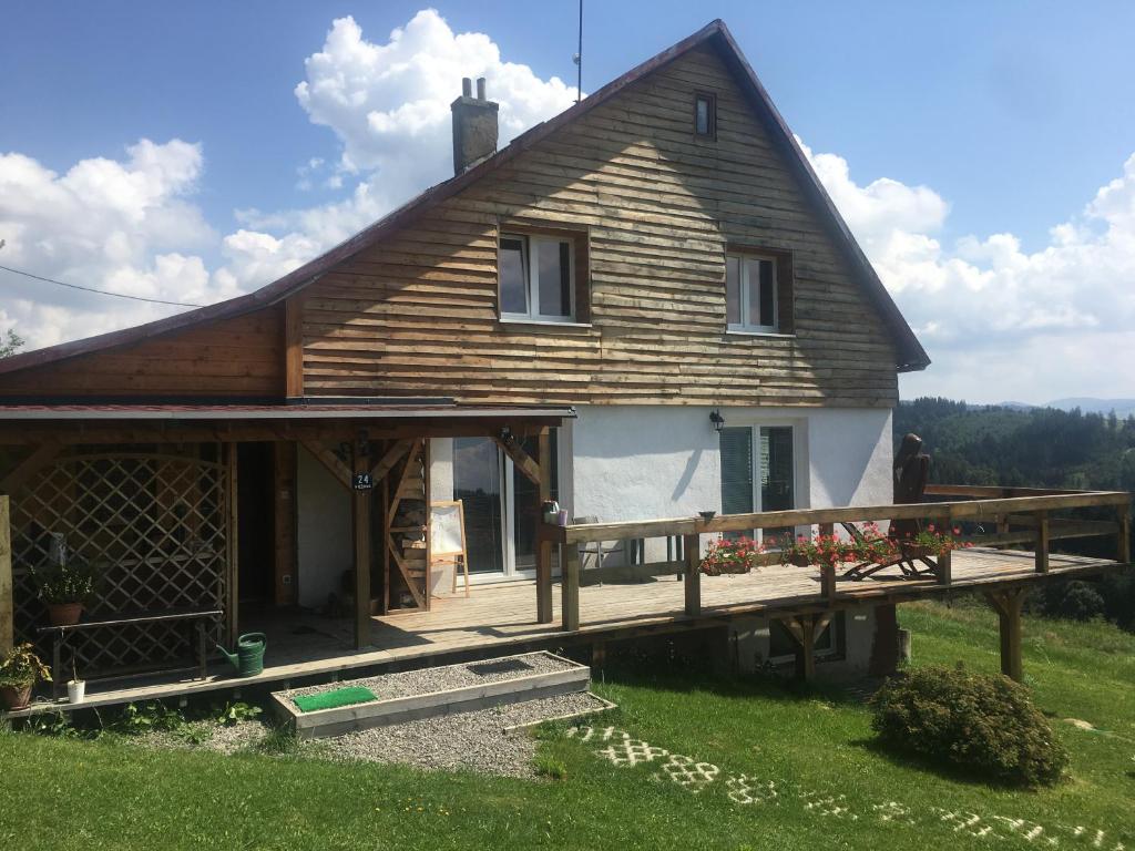 a house with a wooden deck in front of it at Guest House u chalupky in Jablunkov