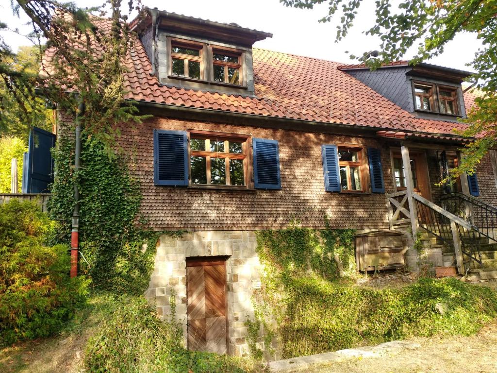 uma velha casa de tijolos com persianas azuis em Rhöner Landhaus mit viel Flair em Gersfeld