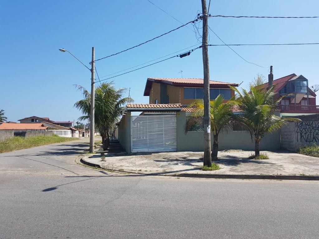 uma casa ao lado de uma rua com palmeiras em Casa temporada Itanhaem em Itanhaém