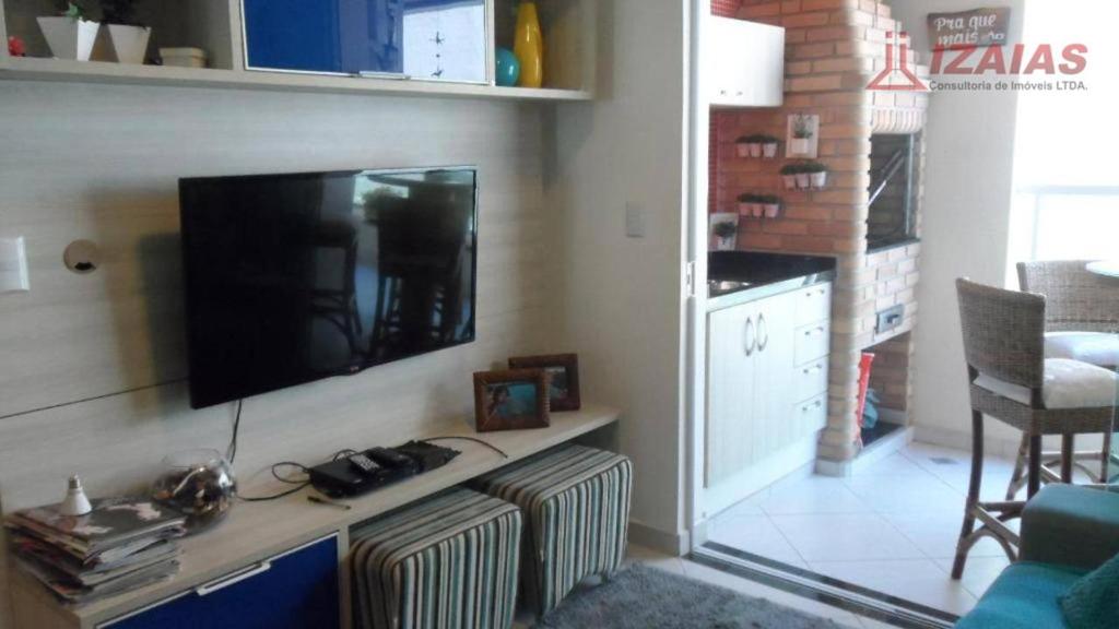 a living room with a flat screen tv on a wall at apartamento pra que mais in Ubatuba