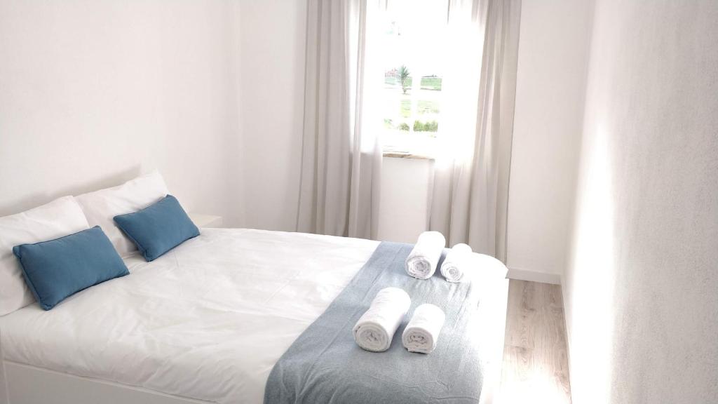 ペニシェにあるCasa dos Avósのベッドルーム(白いベッド、青い枕付)