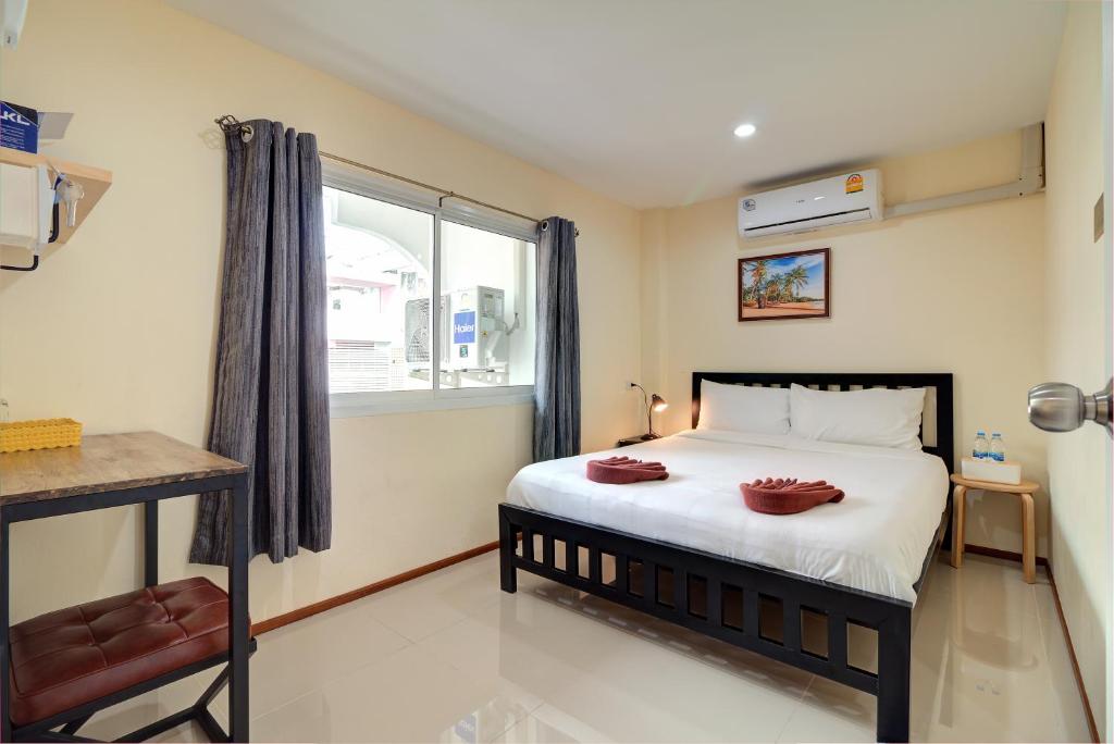 a bedroom with a large bed and a window at Red Pin Inn 好运旅馆 in Bangkok