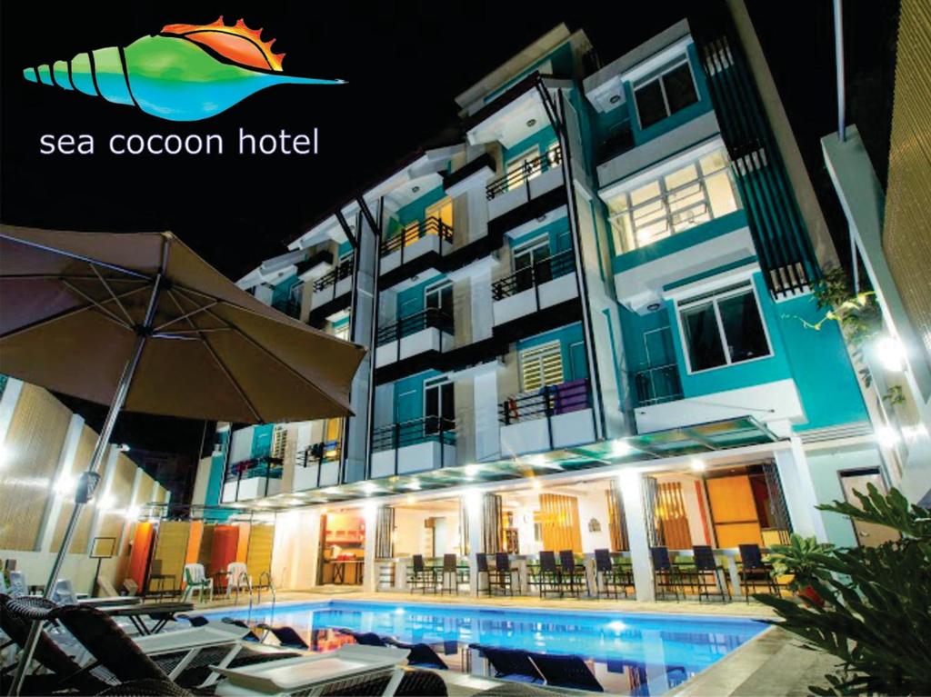 a hotel with a swimming pool in front of a building at Sea Cocoon Hotel in El Nido