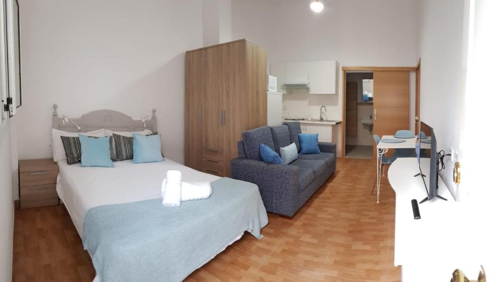 San NicolásにあるLoft en La Aldea de San Nicolasのベッドルーム1室(ベッド1台、ソファ、椅子付)