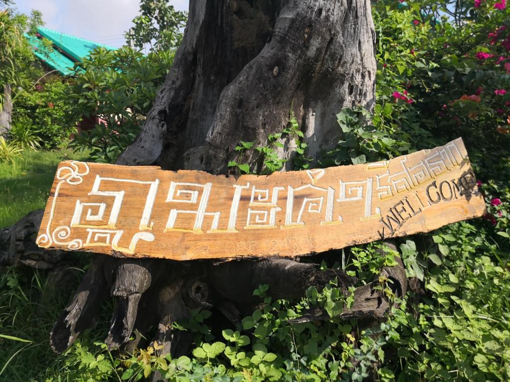 una señal que está pegada a un árbol en Pumaka Resort, en Ban Nong Kok