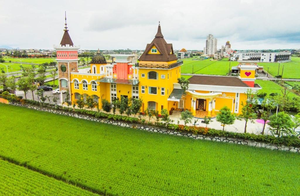 a yellow building with a clock tower on a green field at Jane Castle in Wujie