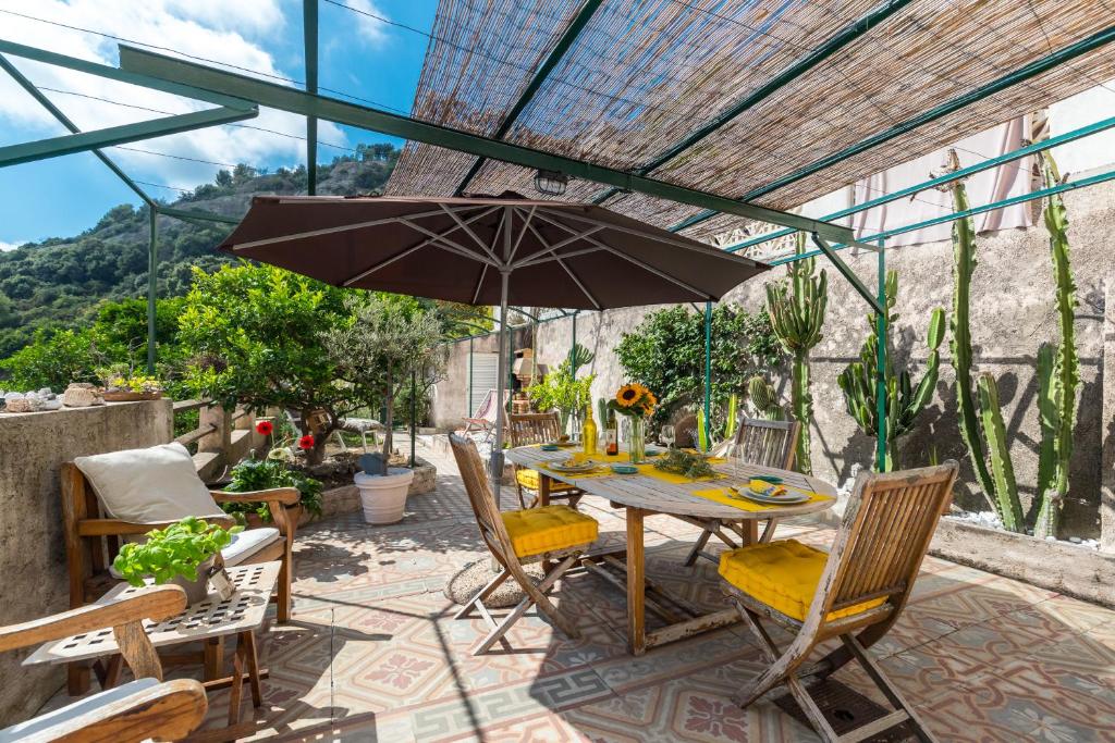La maison des vacances في مينتون: طاولة وكراسي مع مظلة على الفناء