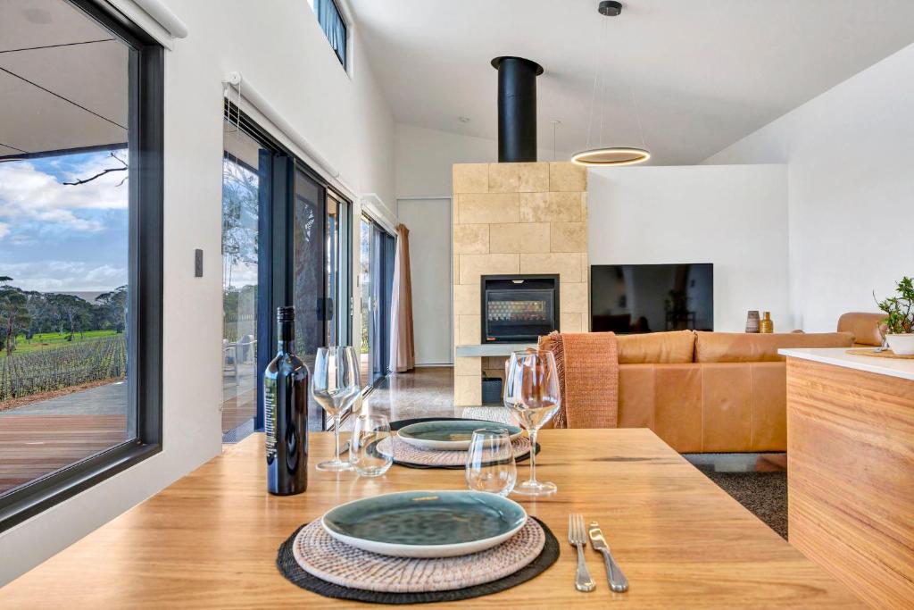 a dining room with a table with wine glasses on it at Shadow Creek McLaren Vale in McLaren Vale