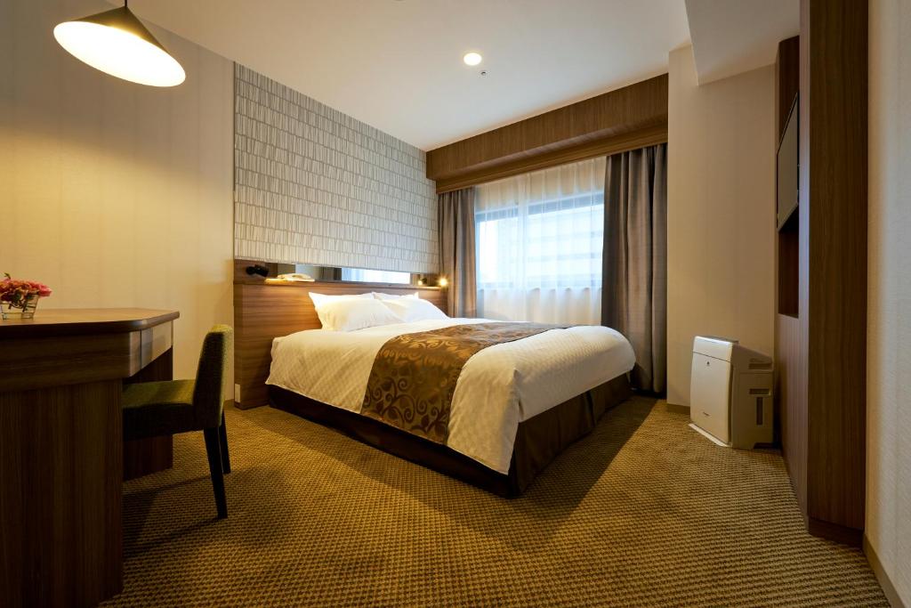 Postel nebo postele na pokoji v ubytování Sendai Kokusai Hotel