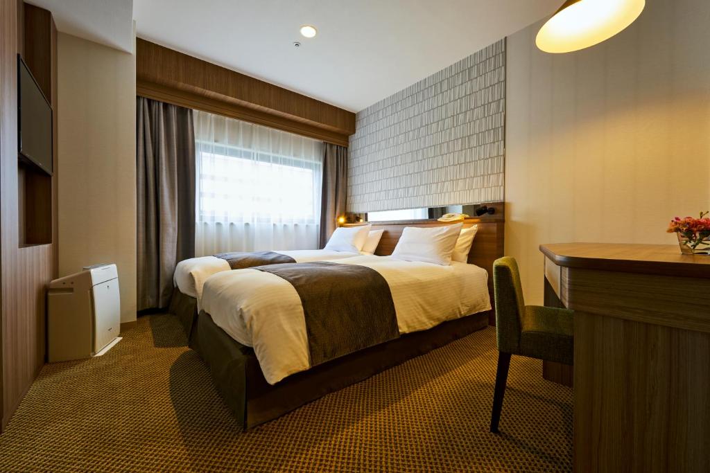 Postel nebo postele na pokoji v ubytování Sendai Kokusai Hotel