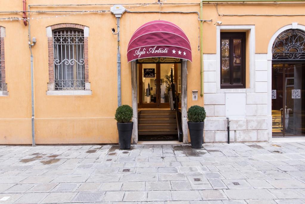 a store front of a building with a purple awning at Hotel Agli Artisti in Venice