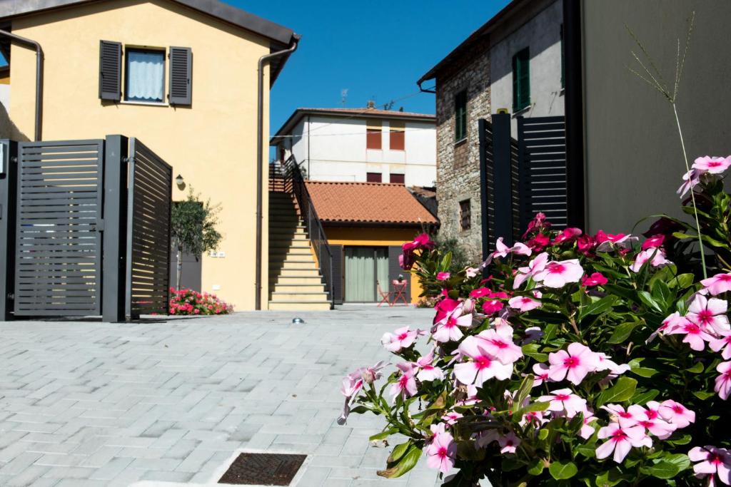 a courtyard with pink flowers in front of a building at Borgo Fratta Holiday Houses in Umbertide