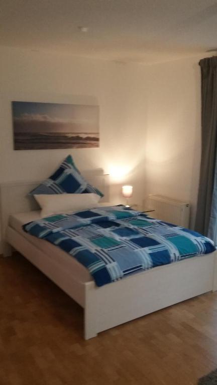 ハノーファーにあるRuhe - Natur - Wasser - Cityのベッドルーム1室(青と白のシーツが備わるベッド1台付)