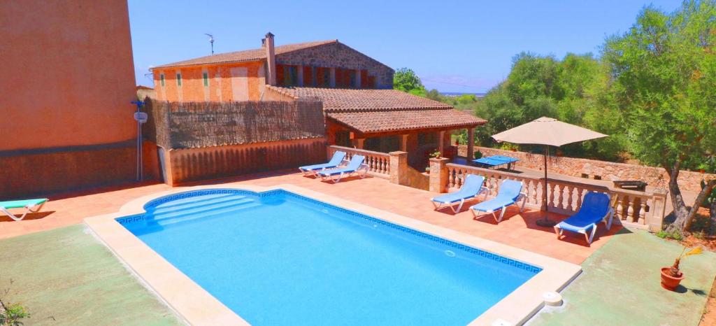 una piscina con sedie e una casa di Can Guillem a Campos