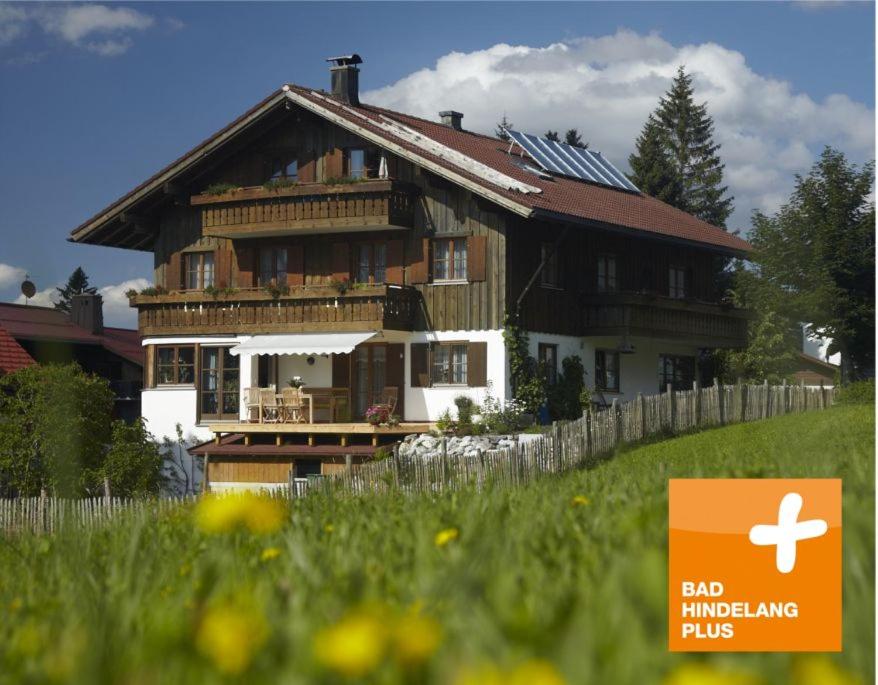 a large wooden house with a sign in front of it at Pension Epple in Oberjoch