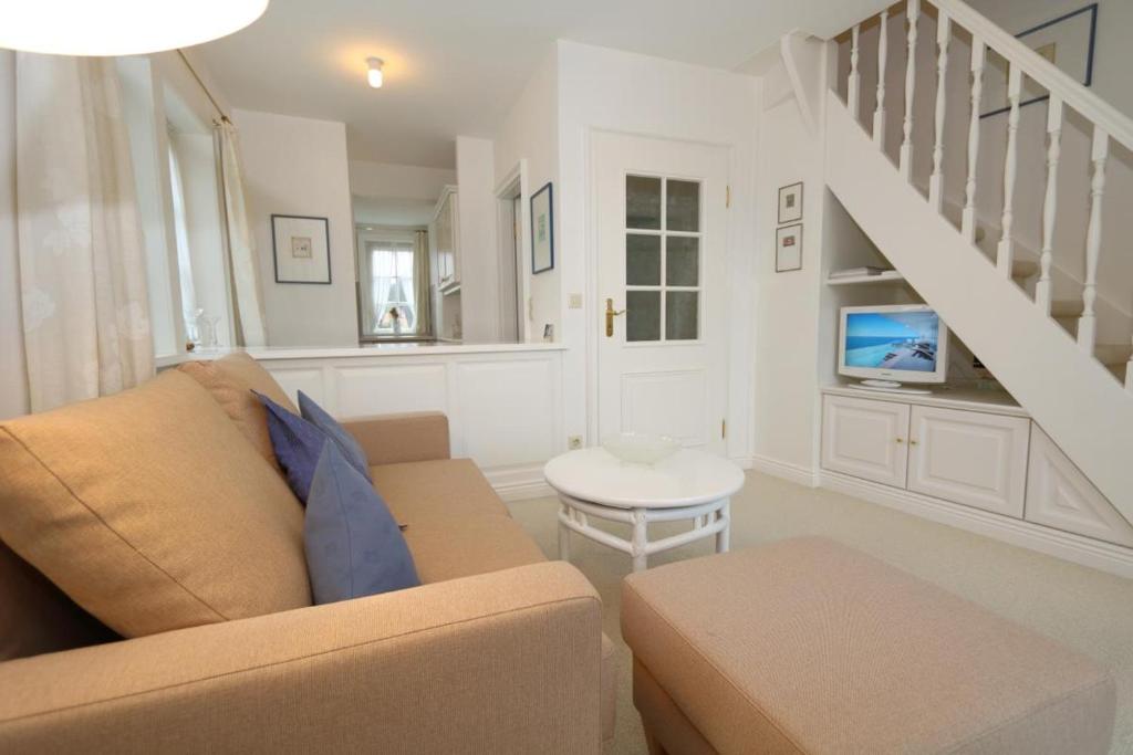 a living room with a couch and a staircase at Inselruhe Munkmarsch in Munkmarsch