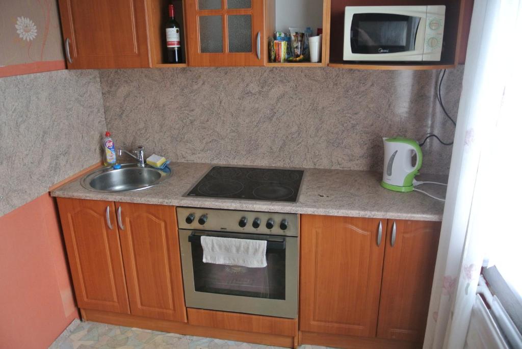 a kitchen with a stove and a sink and a microwave at Tuba in Narva