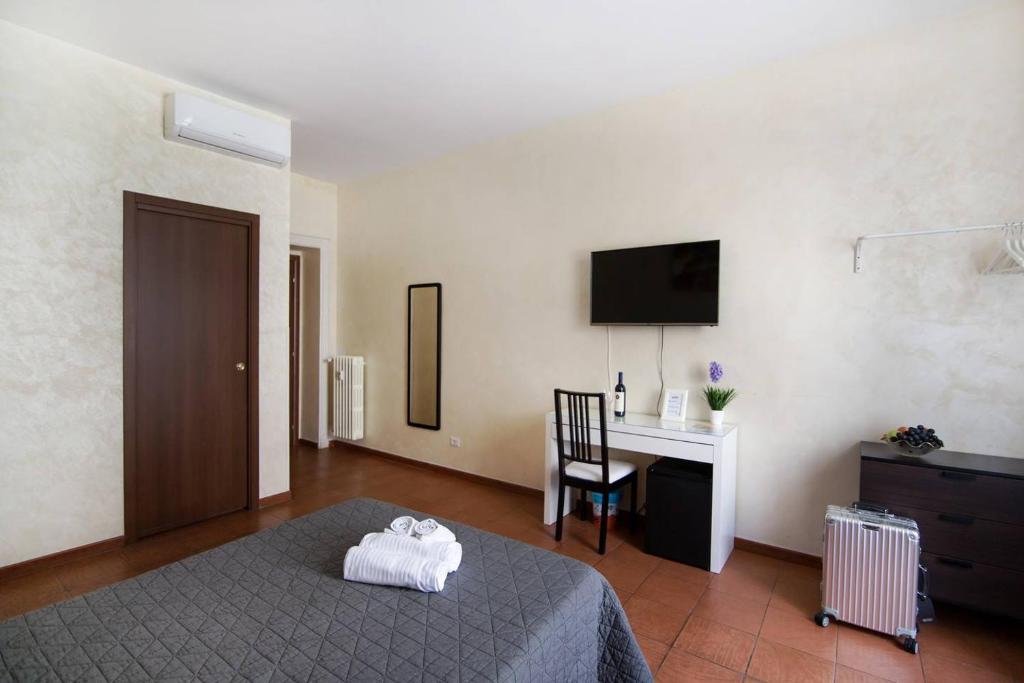 a bedroom with a bed and a desk and a television at Roma Enrico Guesthouse in Rome