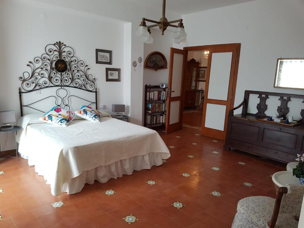 a bedroom with a white bed with a large headboard at La terrazza di Anna in Sassari