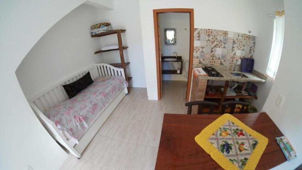 Habitación pequeña con cama y escritorio. en Morada Canto Verde Guarda do Embaú - sinta-se acolhido na ecocasa da Dete en Guarda do Embaú