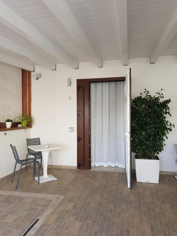 a room with a table and chairs and a door at Hotel Perla Gaia in San Vito lo Capo