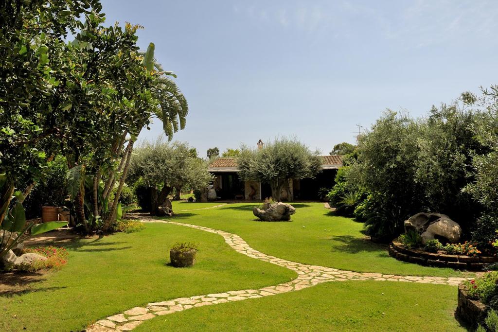 un giardino con sentiero in pietra nell'erba di Villa Charlie a Villasimius