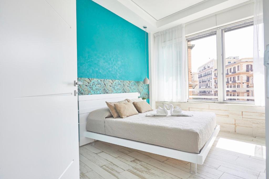 una camera con letto e parete blu di Luxury Experience | WelcHome Napoli a Napoli