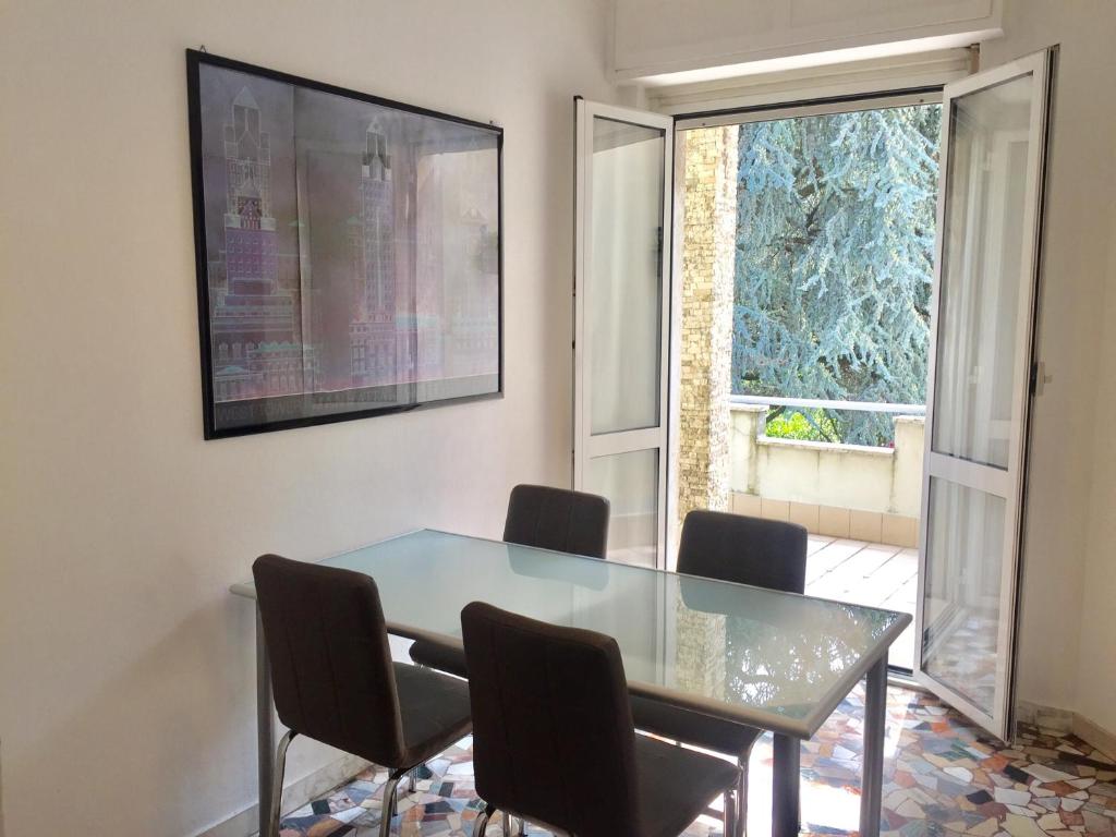 ein Esszimmer mit einem Tisch, Stühlen und einem Fenster in der Unterkunft Il Cedro Argentato in Monza
