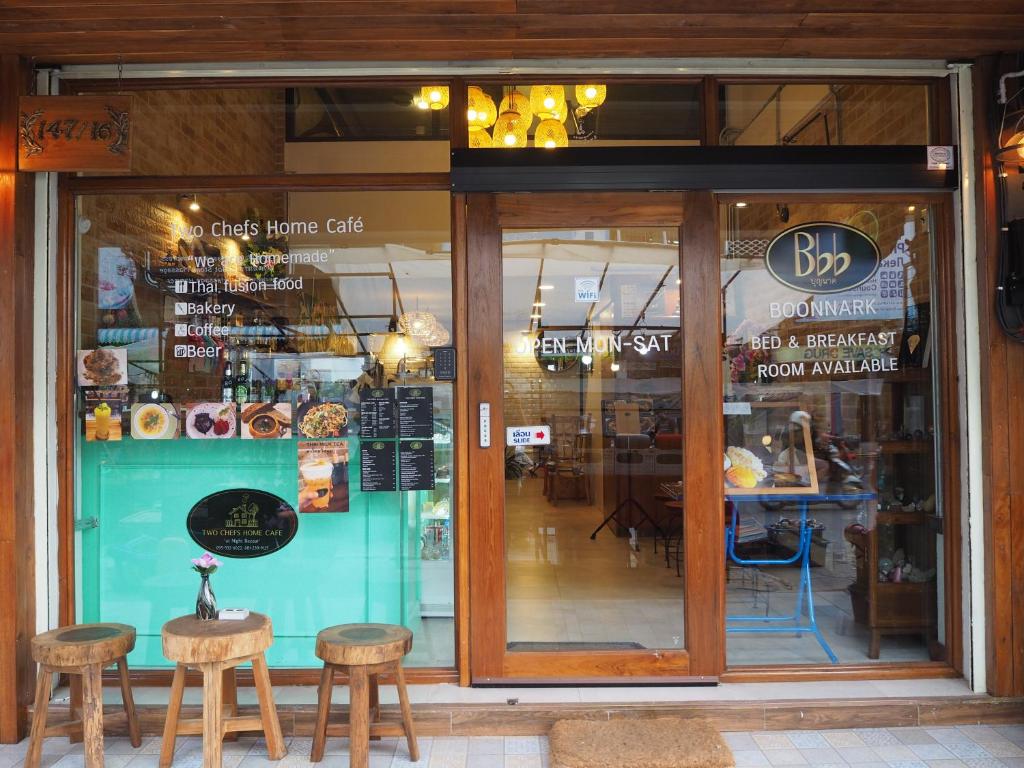 un magasin avec deux tables et deux tabourets devant une fenêtre dans l'établissement Boonnark Bed Night Bazaar no car parking, à Chiang Mai