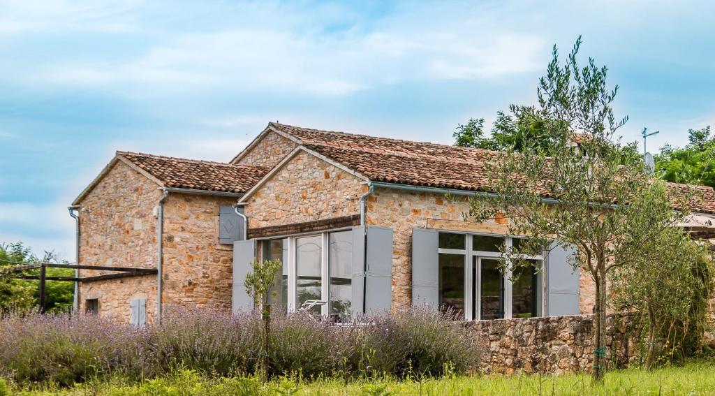 a stone house with a large window in a field at Tenuta Paljari in Vižinada