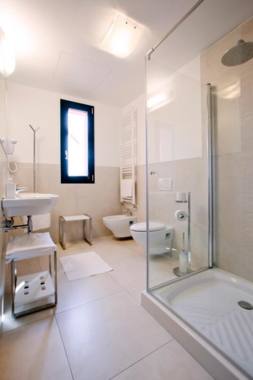 a bathroom with a shower and a sink and a toilet at Hotel Marco Polo in Lido di Jesolo