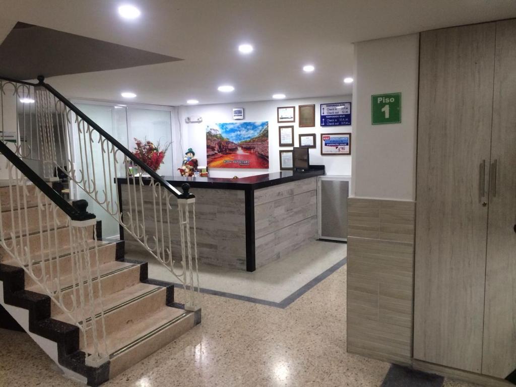 a lobby with a staircase and a counter in a building at Hotel Napolitano in Villavicencio