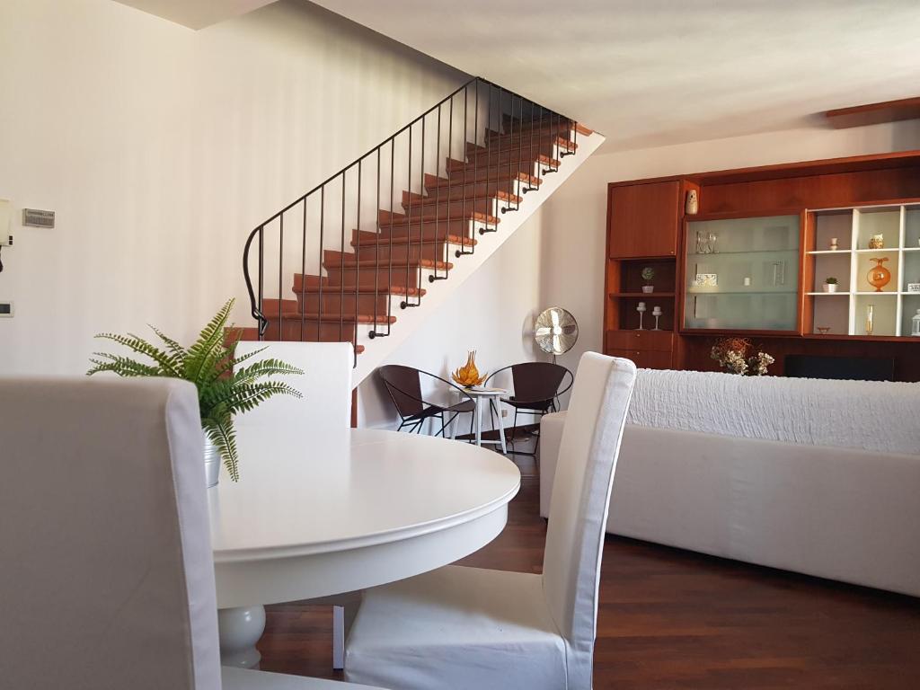 a dining room with a white table and chairs at In Piazzetta in Pisa