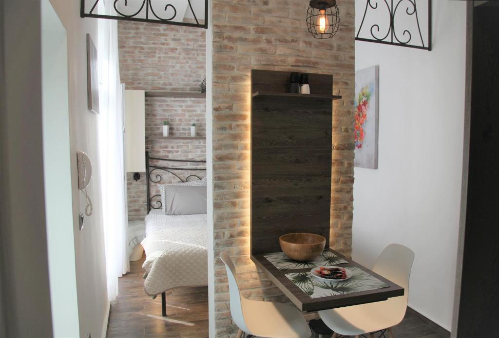a room with a brick wall and a table and chairs at Al Mattina Apartments Belgrade in Belgrade
