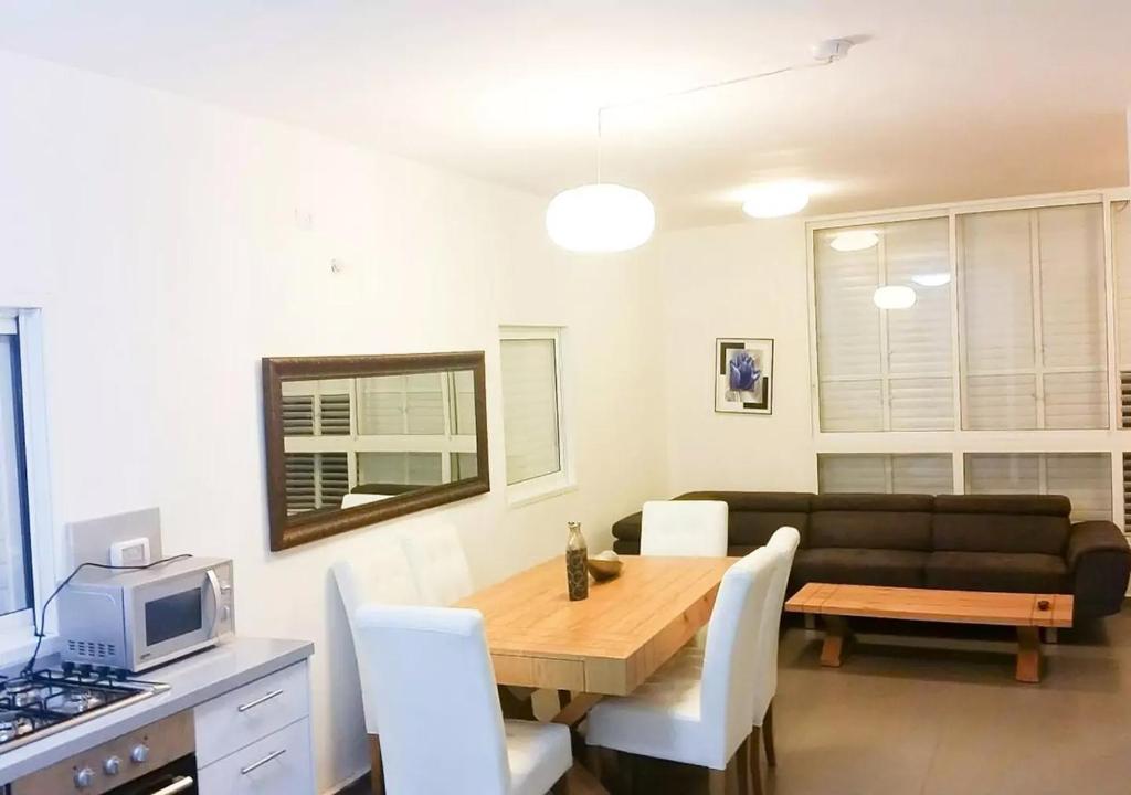 a living room with a table and a couch at Oַ&O Group- Cozy APT Bat-Yam 3 Min Walk To Beach in Bat Yam
